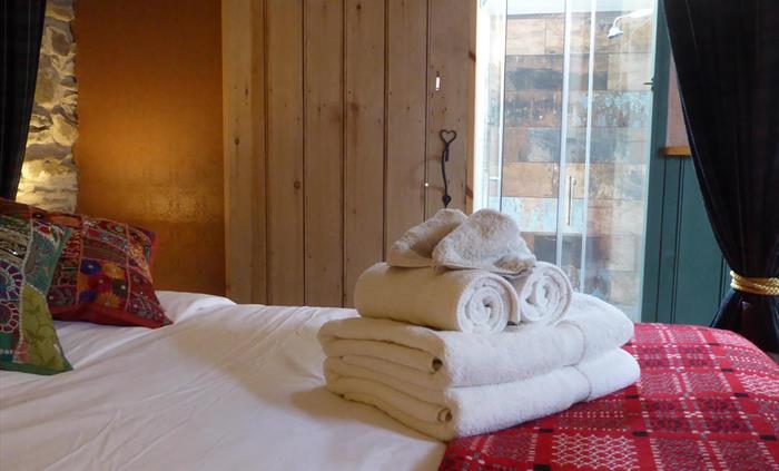 Four-poster tester bed, and soft, thick, luxurious organic cotton bath towels on the bed.